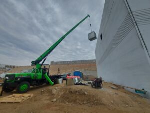 Grúa industrial elevando equipo pesado en instalación industrial