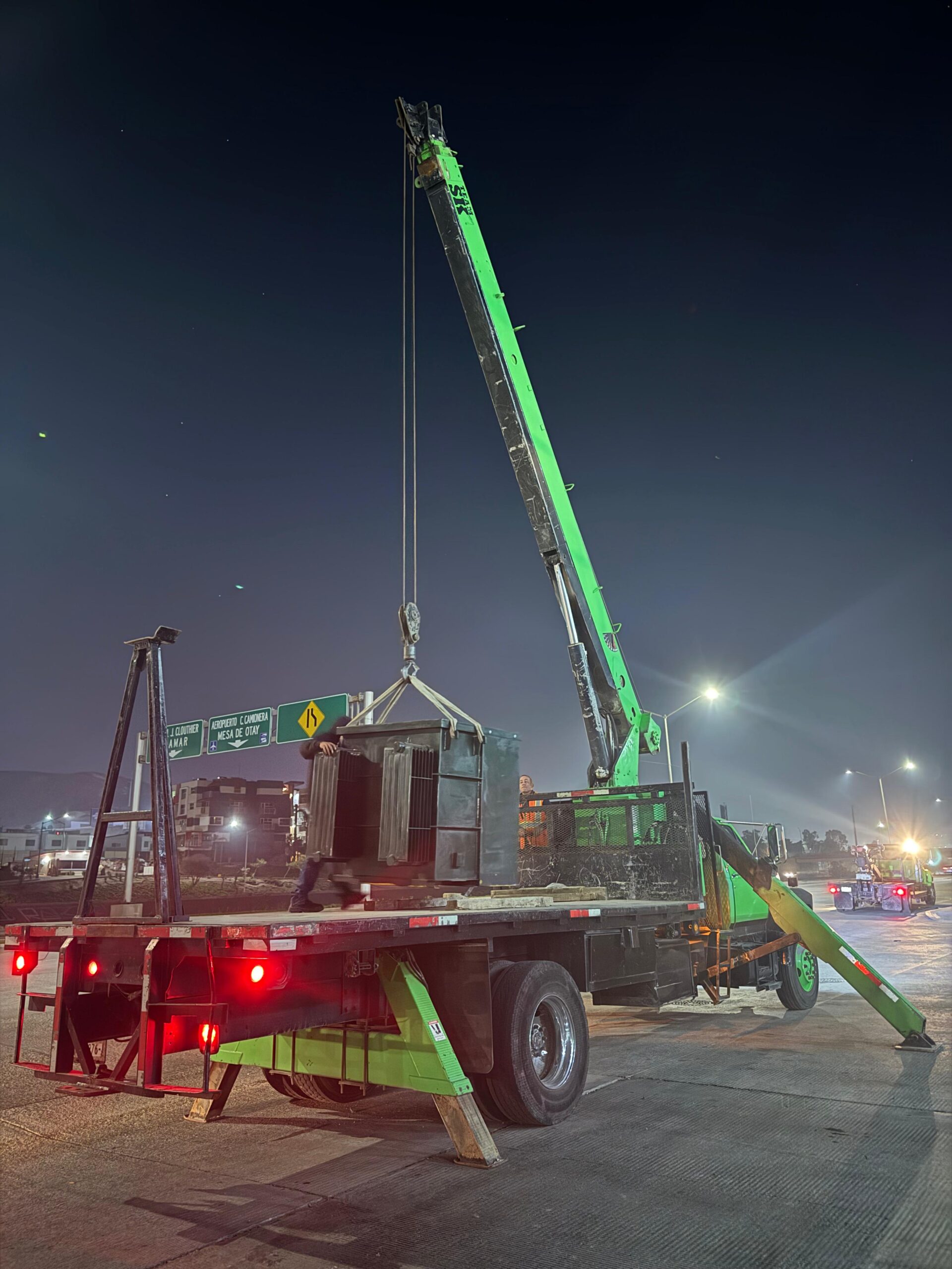 Grúa realizando maniobra nocturna en vialidad de Tijuana
